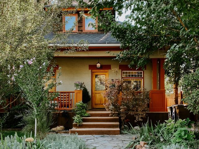 Craftsman-style house with a wooden front door and a stone path through the garden